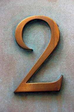 Pirinç bir figür '2', sıklıkla temiz ovulmuş ve verdigris oksitlenmiş bakır kireç taşı duvara sızıyor. Londra 'da bir ofis binasının dışında halka açık bir yerde sergileniyor.