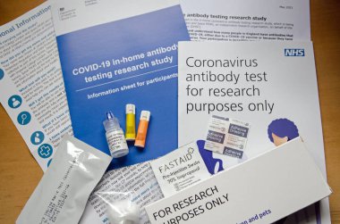 Basingstoke, İngiltere - 13 Mayıs 2021: NHS COVID-19 antikor testi için ekipman ve evrak. Kraliyet Koleji 'nin bir parçası olarak İngiltere' de kaç kişinin koronavirüse karşı antikoru olduğunu bulmak için yapılan araştırmaya göre.
