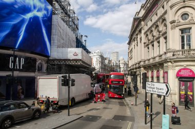 Londra, İngiltere - 16 Nisan 2021: Güneşli bir öğleden sonra Londra 'da Shaftesbury Bulvarı' nın aşağısındaki kalabalığın ve trafiğin görüntüsü hafifçe yükseldi.