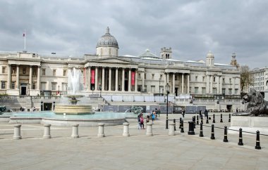 Londra, İngiltere - 21 Nisan 2021: Trafalgar Meydanı boyunca serin bir bahar gününde Londra 'nın merkezindeki Ulusal Galeriye doğru hafif yükseltilmiş manzara.
