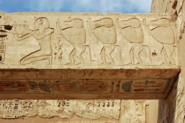 Stone lintel in the Ancient Egyptian temple of Medinet Habu carved with the images of the great Pharaoh Ramses II and a line of baboons.  West Bank of the River Nile in Luxor, Egypt.