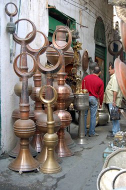 Trablus, Libya - 4 Nisan 2006: Libya 'nın eski Trablus kentindeki metal pazarında sergilenen el sanatlarına bakan iki adam.