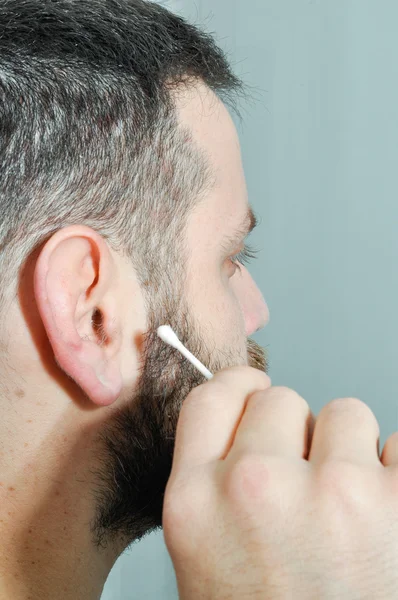 Kirli kulak olan adam. Genç adam onun kulak temizleme. Yetişkin alarak onun vücut bakımı. Adam pamuk tomurcukları ile.