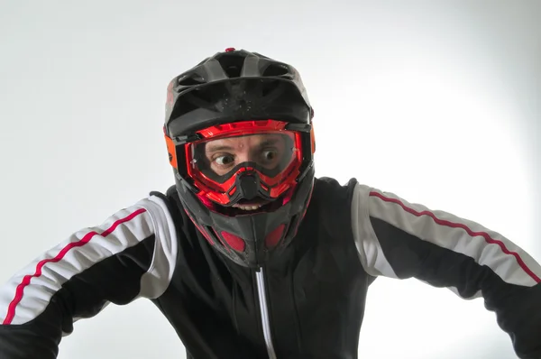 Korkan bir adam. Kask ve gözlük dağ bisikleti olan adam. Adamın gözleri tamamen açık.