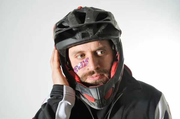 Yama ile yaralı adam. Kask ve sıfırdan yüzünde olan adam. Kask ve yüzünde küçük yara ile genç adam.