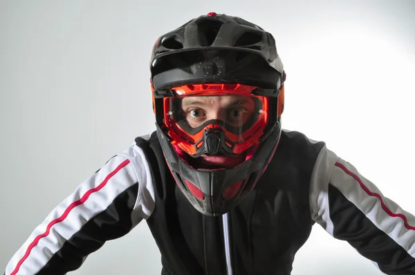 Korkan bir adam. Kask ve gözlük dağ bisikleti olan adam. Adamın gözleri tamamen açık.