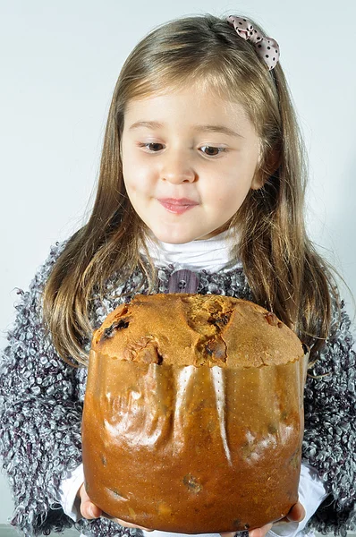 Little girl with panettone at Christmas. Panettone Christmas cake. Litte girl with Italian panetone in Christmas holidays.