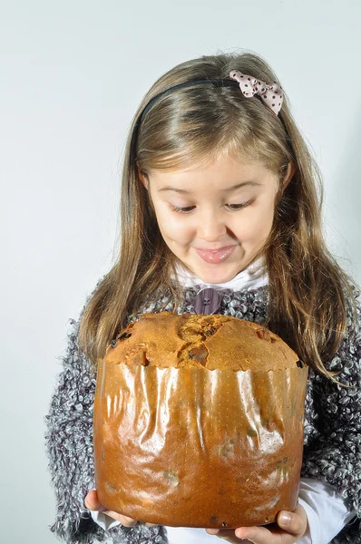 Little girl with panettone at Christmas. Panettone Christmas cake. Litte girl with Italian panetone in Christmas holidays.