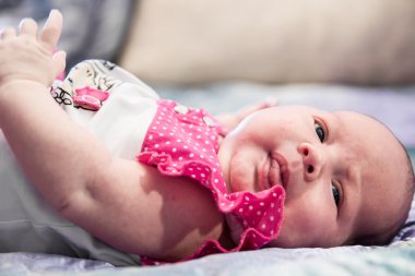 Pembe elbiseli şirin bebek kız dil eğlenceli gösterir