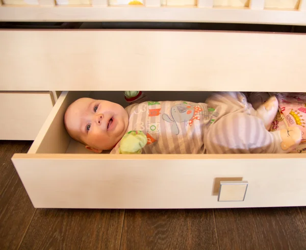 Funny cute baby girl in a drawer for things