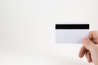 El beyaz zemin üzerinde bir kredi kartı ile