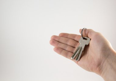 Beyaz bir arka plan üzerinde elinde tuşları