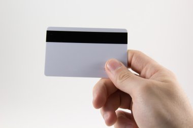 El beyaz zemin üzerinde bir kredi kartı ile