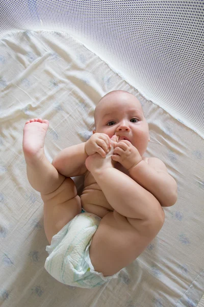 Divertido niño jugando con su pie —  Fotos de Stock