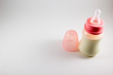 Biberon ile süt ve beyaz bir arka plan üzerinde emzik