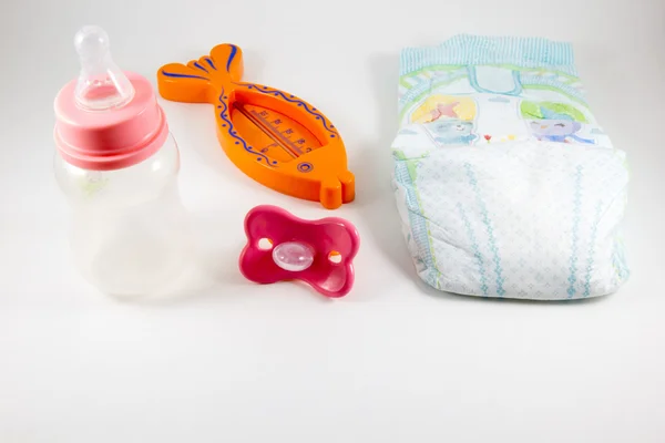 병, pacifiers, 그리고 흰색 바탕에 아기 기저귀 — 스톡 사진