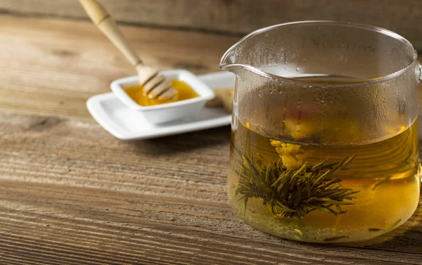 Teekanne mit blühender Teeblume und Honig Stockfoto