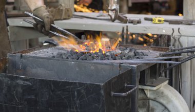 Demirci metalle çalışıyor.