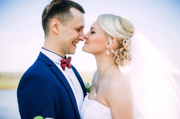 Gelukkig en mooi bruid en bruidegom tedere kus in de lente outdoo — Stockfoto