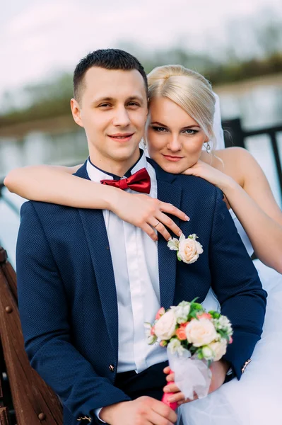 Braut und Bräutigam am Hochzeitstag umarmen sich im Freien an der Frühlingsnatur — Stockfoto