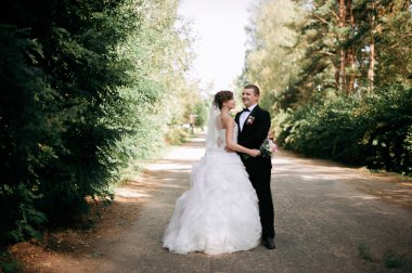 Zarif genç mutlu evlilik çift yeşil çimlere oturup 