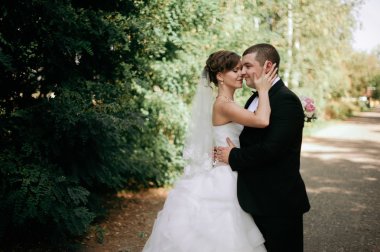 Zarif genç mutlu evlilik çift yeşil çimlere oturup 