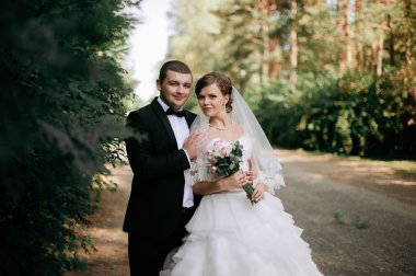 Zarif genç mutlu evlilik çift yeşil çimlere oturup 