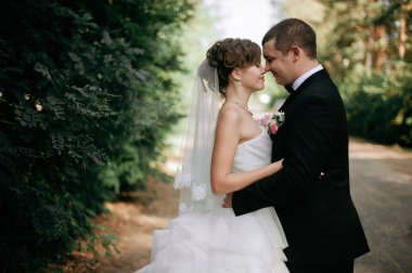 Zarif genç mutlu evlilik çift yeşil çimlere oturup 