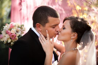 Zarif genç mutlu evlilik çift yeşil çimlere oturup 