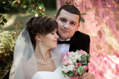 Zarif genç mutlu evlilik çift yeşil çimlere oturup 