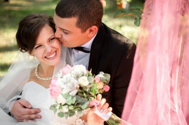 Zarif genç mutlu evlilik çift yeşil çimlere oturup 