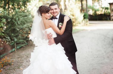 Zarif genç mutlu evlilik çift yeşil çimlere oturup 