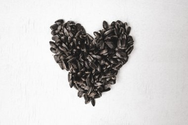 Beyaz arkaplanda siyah ayçiçeği tohumları