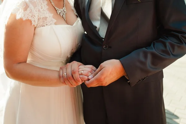 Yeni evliler el ele tutuşarak öpüşmeyle düğün buketi — Stok fotoğraf