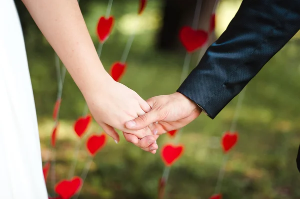 Bouquet da sposa su baci sposi che si tengono per mano — Foto Stock