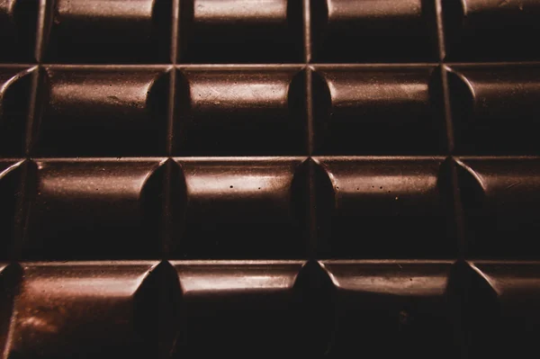 Čokoláda na dřevěný stůl na tmavém pozadí — Stock fotografie
