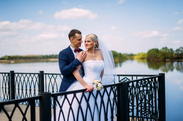 Glad och vacker brudgummen och bruden anbud kyss på våren utomhu — Stockfoto