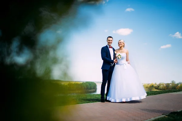 Gelukkig en mooi bruid en bruidegom tedere kus in de lente outdoo — Stockfoto