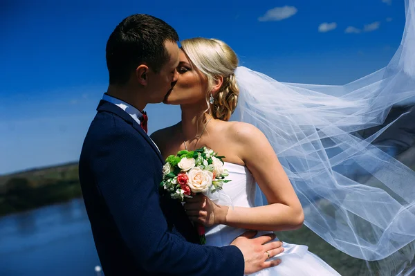 Щасливий і красивий наречений і ніжний поцілунок нареченої на весняному виїзді — стокове фото