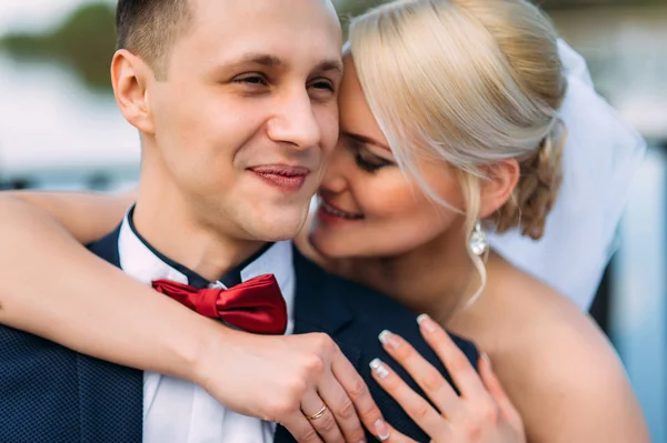 Braut und Bräutigam am Hochzeitstag umarmen sich im Freien an der Frühlingsnatur — Stockfoto