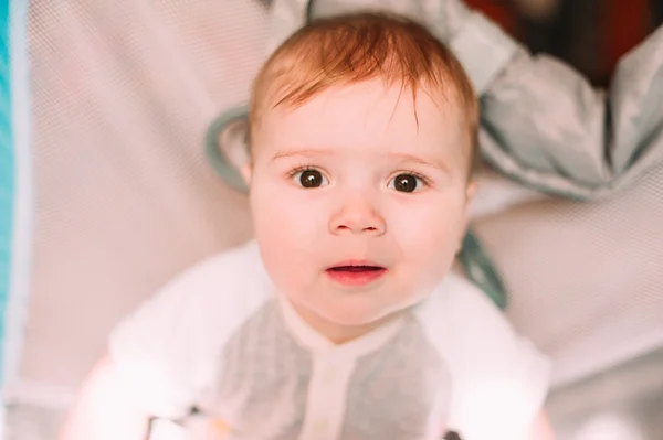 Cute little baby boy playing in colorful playpen, indoors. Beautiful child having fun at nursery. — Stock Photo, Image