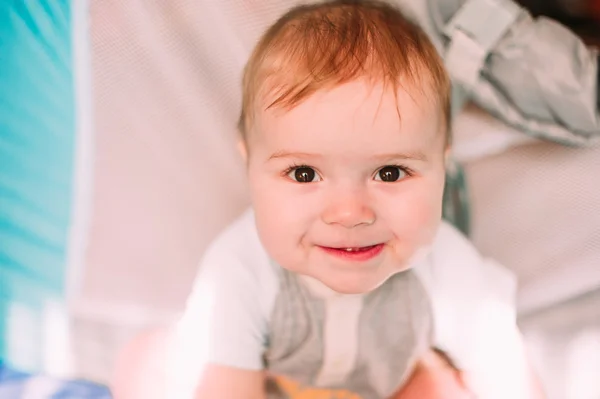 Cute little baby boy playing in colorful playpen, indoors. Beautiful child having fun at nursery. — Stock Photo, Image