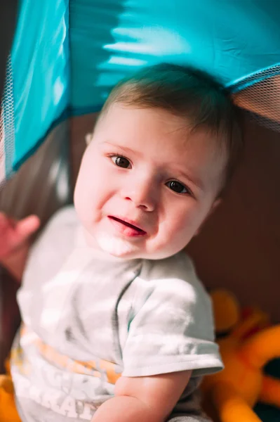 Cute little baby boy playing in colorful playpen, indoors. Beautiful child having fun at nursery. — Stock Photo, Image