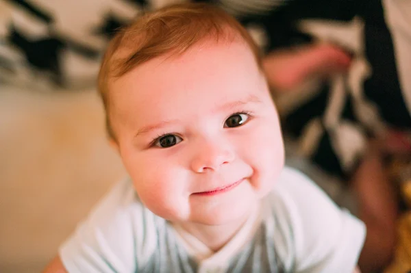 Close-up retrato de um bebê bonito alegre no berço em casa — Fotografia de Stock