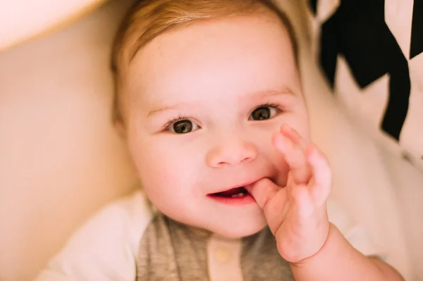 Close-up retrato de um bebê bonito alegre no berço em casa — Fotografia de Stock