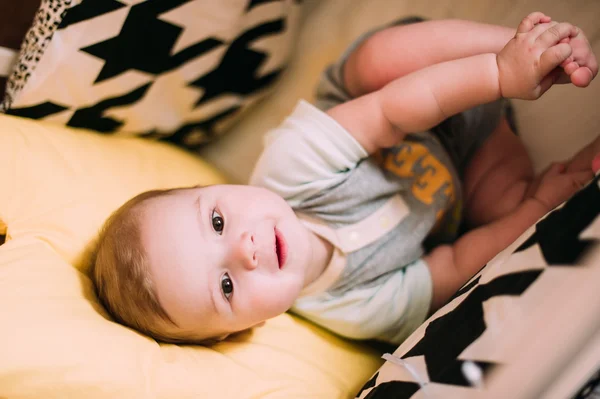 Retrato de cerca de un lindo bebé alegre en la cuna en casa —  Fotos de Stock