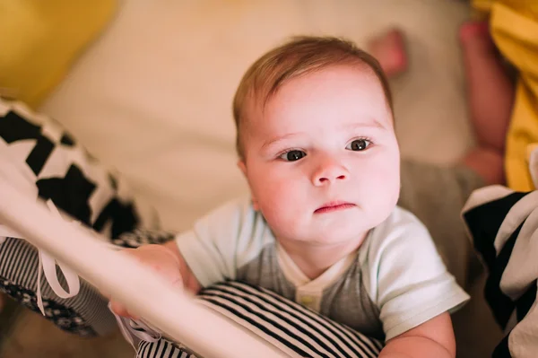 Крупный план портрета веселого милого малыша в кроватке дома — стоковое фото