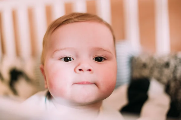 Close-up retrato de um bebê bonito alegre no berço em casa — Fotografia de Stock