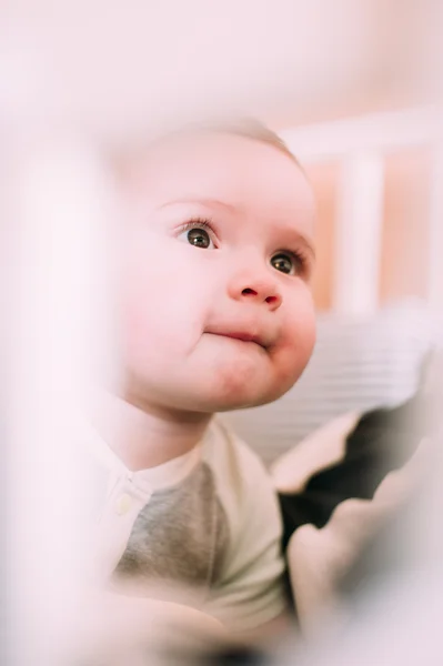 Close-up portret van een vrolijke, schattige baby in de wieg thuis — Stockfoto