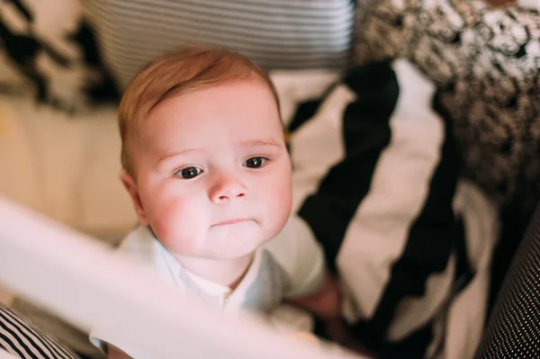 Close-up retrato de um bebê bonito alegre no berço em casa — Fotografia de Stock